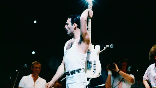 Freddie Mercury wields a guitar at Live Aid
