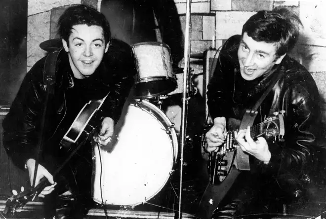 Paul McCartney and John Lennon performing alongside one another in 1961.