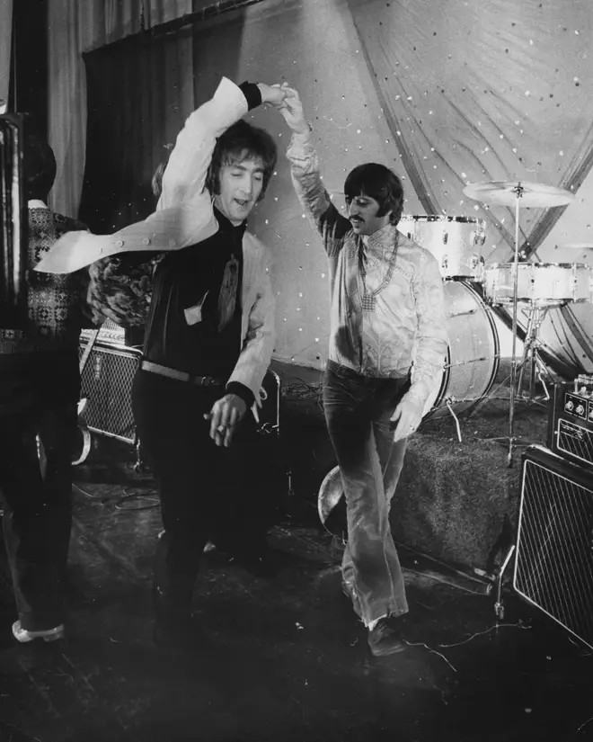 John Lennon and Ringo Starr dancing together.