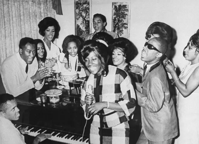 Motown founder Berry Gordy Jr. playing the piano as a group including Smokey Robinson and Stevie Wonder join in singing together at Motown Studios in 1964